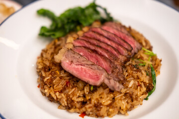 Stir-fried Basil with Rare beef steak served on plate. It is a popular Thai dish known as Pad Kra Pao
