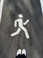 A white pedestrian figure on the sidewalk indicates the direction of pedestrian movement