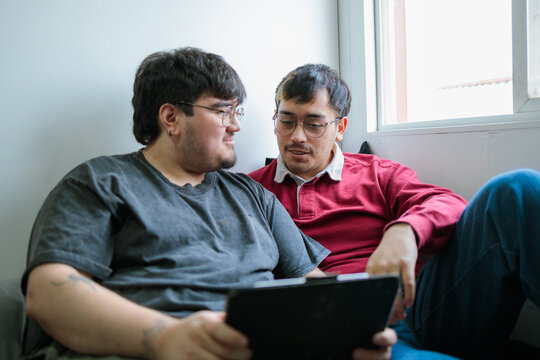 Two latin men using a tablet together