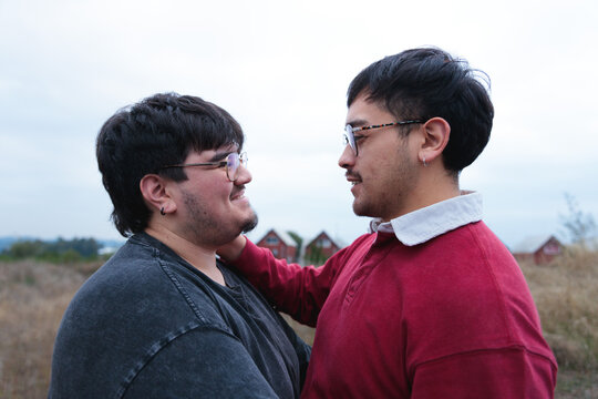 Latin gay couple looking at each other in nature