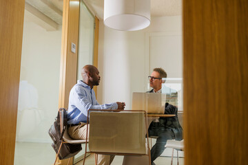 Two businessmen discussing strategy in modern office meeting room