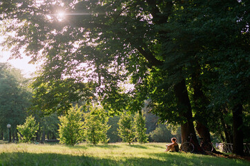 Woman sitting under big tree 