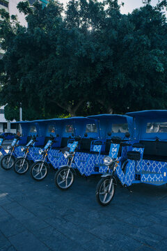 Blue Moroccan Pattern Tuk-Tuks/Rickshaws Lined Up in Urban Setting