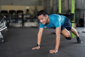 Fitness: Man Engaging in Push-Up Variation in Gym