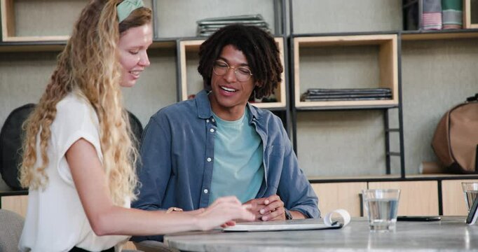 After explaining diverse team leaning at office filing clipboard signing contract and shaking hands