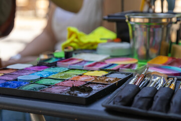 Makeup artist preparing colorful palette and brushes for face painting
