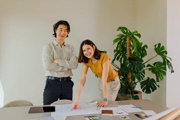 Architects reviewing plans in modern office with plants