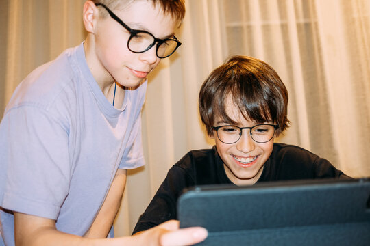 Boys enjoy educational activity while using a tablet indoors