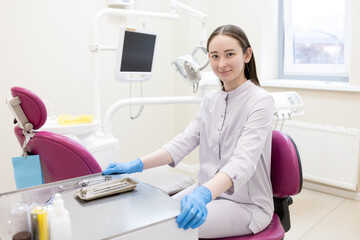 Portrait of female dentist. She's standing in her dentist office.
