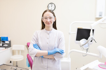 Portrait of female dentist. She's standing in her dentist office.