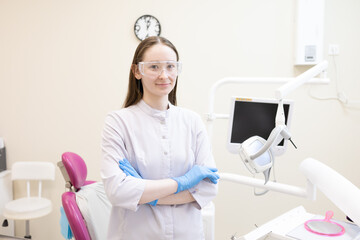 Portrait of female dentist. She's standing in her dentist office.