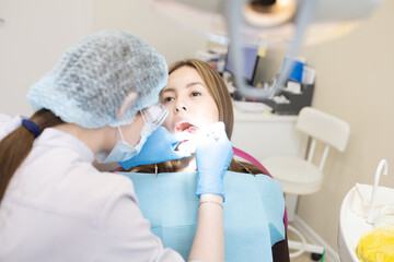 The dentist examines the patient's oral cavity. teeth
