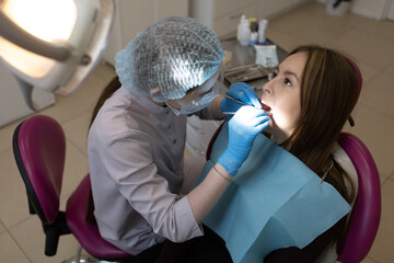 The dentist examines the patient's oral cavity. teeth