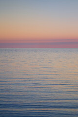 Beautiful and tranquil pastel-colored seascape and sky at sunset. Abstract natural landscape and background with copy space.
