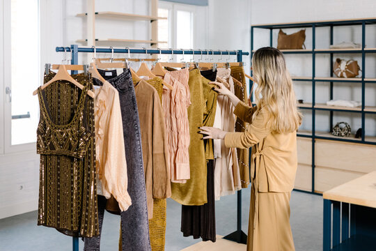 Woman looking through different clothes on a rack in a fashion store