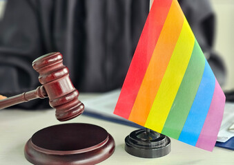Judicial gavel beside a rainbow flag representing LGBTQ rights in a legal setting