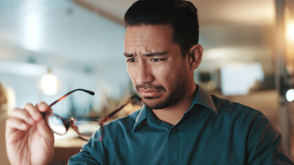 Man, glasses and vision strain in office for wrong prescription, bad eyesight and lens mistake. Male person, squinting and check frame for dirty eyewear, optical challenge and impairment issues