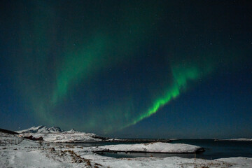 Wide angle shot of the aurora borealis, the northern lights, over the Norwegian islands near Mjelle on a winter evening.