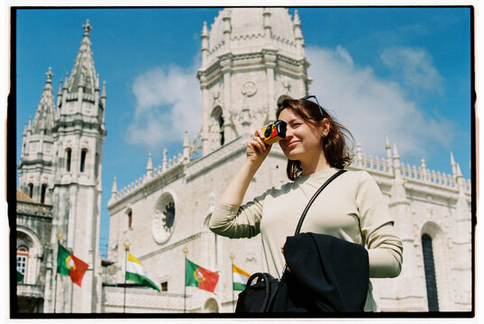 Female tourist taking photos with disposable camera in Lisbon - Powered by Adobe