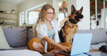 Laptop, smile and dog with woman on sofa for pet insurance research, premium benefits and online. Animal policy cover, typing and application with person and german shepherd at home for vet claims