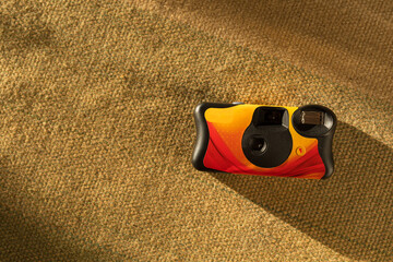 Colorful disposable film camera on green fabric