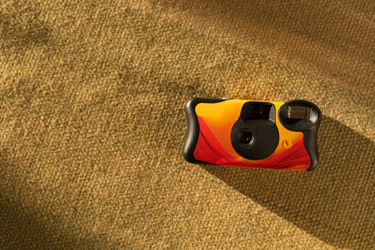 Colorful disposable film camera on green fabric