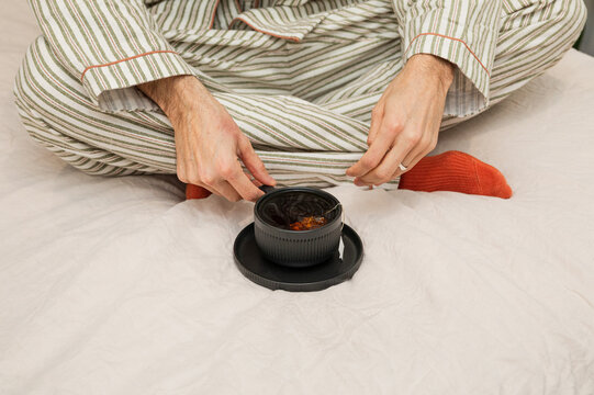 Morning tea ritual on a cozy bed with pajamas
