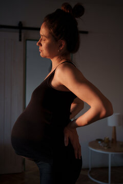 Pregnant Woman Relaxing at Home in Soft Evening Light