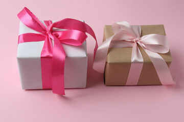 Gift box with a bow on a pink background, top view. Space for text