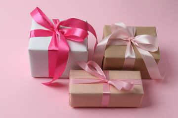 Gift box with a bow on a pink background, top view. Space for text