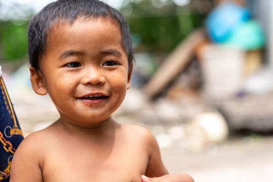 Young Thai boy smiling happily with chocolate in rural area.