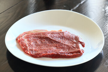 a piece of raw meat, steak on a plate, beef