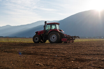 Tractor in farmland at sunrise