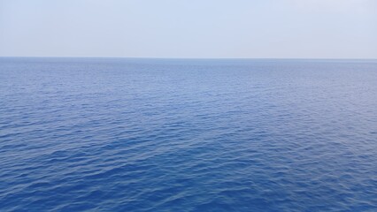 Obraz premium Calm and expansive view of the ocean under clear blue sky on a sunny day.