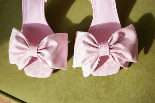 Closeup of pink bow sandals on green surface