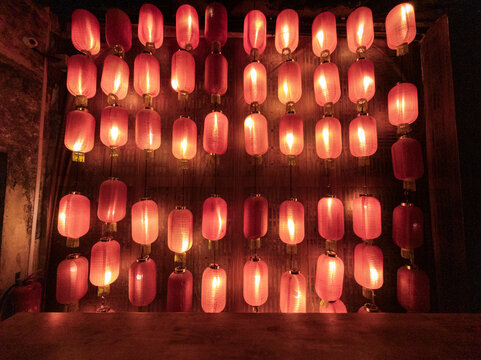 Warm red lanterns decorating rustic wooden wall