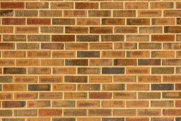 Abstract texture background of an exterior multi-shade reddish brown vintage brick wall surface speckled with blue, in traditional running bond brickwork pattern