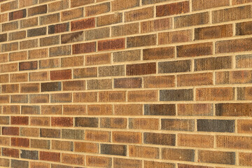 Abstract texture background of an exterior multi-shade reddish brown vintage brick wall surface speckled with blue, in traditional running bond brickwork pattern