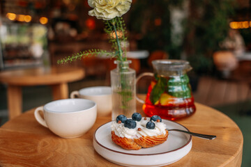 sweet dessert with berries in a cafe. rooibos tea and 2 tea cups are on the table nearby