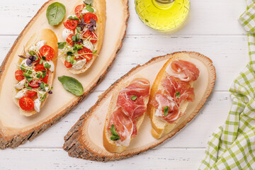 Tasty antipasto toasts featuring classic caprese with mozzarella and tomatoes, and savory prosciutto with herbs