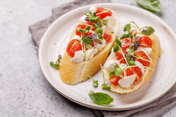Tasty antipasto toasts featuring classic caprese with mozzarella and tomatoes, and savory prosciutto with herbs