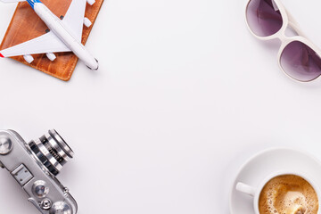 Travel-themed flat lay with toy airplane, camera, and coffee