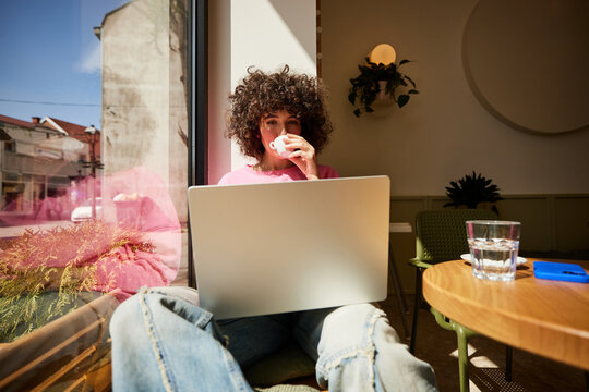 Woman uses a laptop in a cafe