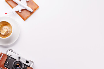 Travel-themed flat lay with toy airplane, camera, and coffee