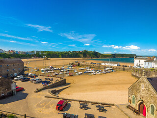Obraz premium Tenby, Wales, United Kingdom - 26th June 2024 - Tenby Harbour with boats grounded by low tide