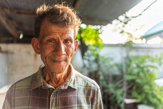 Elderly Street Sweeper Smiling in Sunset Light Indoors