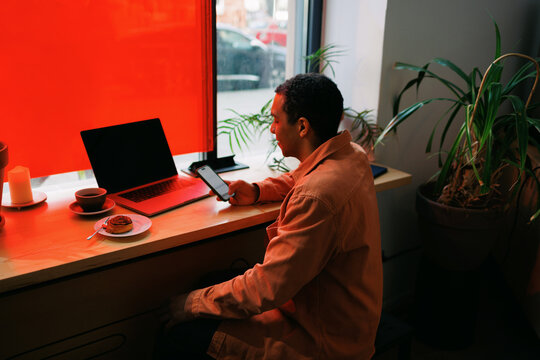 Man Relaxing with Phone Caf&eacute; Moment with Coffee and Laptop