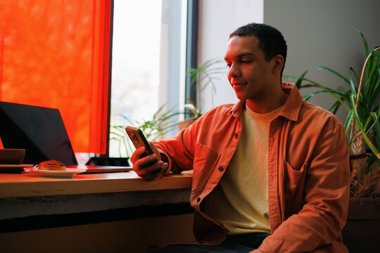 Man Relaxing with Phone in Caf&eacute; Setting