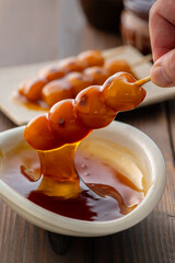 A close-up of traditional Japanese mitarashi dango—skewered rice dumplings grilled to perfection and coated with a glossy, sweet soy sauce glaze. The caramelized surface and rich glaze highlight the a