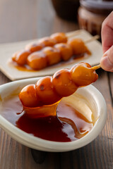 A close-up of traditional Japanese mitarashi dango&mdash;skewered rice dumplings grilled to perfection and coated with a glossy, sweet soy sauce glaze. The caramelized surface and rich glaze highlight the a